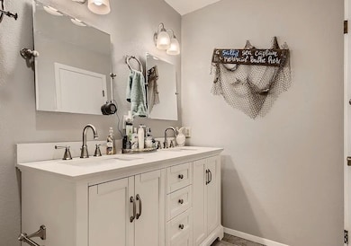 Bathroom featuring a textured wall and double vanity