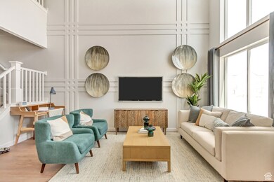 PHOTO FROM SIMILAR MODEL HOME. COLORS, OPTIONS, AND FEATURES WILL VARY: Living area featuring stairway, wood finished floors, and a towering ceiling