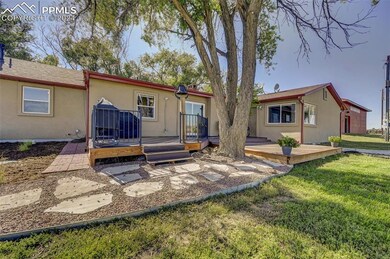 Rear view of property featuring a deck and a yard