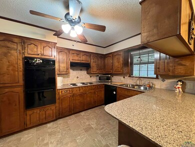 Kitchen with light stone countertops, ceiling fan,