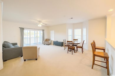 Living room with ornamental molding, light colored carpet, and a ceiling fan