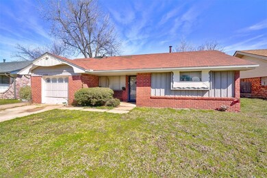 Ranch-style home featuring a garage, driveway, bri