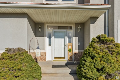 Entrance to property featuring stucco siding, stone siding, and a porch