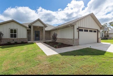 View of front of home with a garage and a front ya