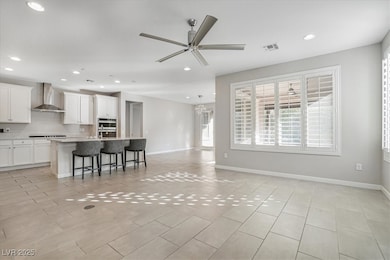 Kitchen with wall chimney exhaust hood, open floor