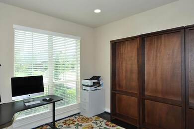 A bright window and wood flooring accent this versatile space which could also become a music room, library or formal living area.