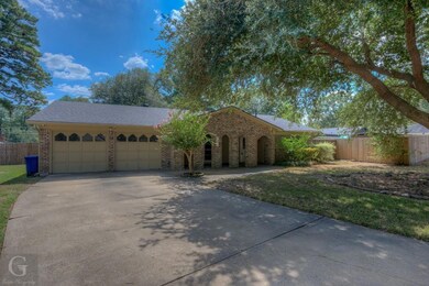 Ranch-style home featuring concrete driveway, fenc
