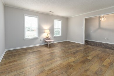 Spacious room with new flooring opens into dining 