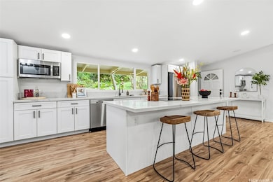 Bright and cheerful kitchen with convenient breakfast bar that also provides ample counter space for food prep.