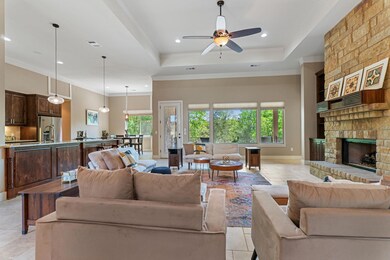 Living area with a ceiling fan, a stone fireplace