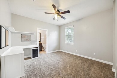 First floor bedroom with ceiling fan and walk-in c