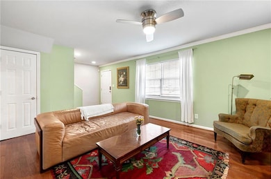 Living area featuring wood finished floors, a ceiling fan, ornamental molding, and recessed lighting