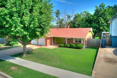 View of front of property featuring driveway, an attached garage, a chimney, and brick siding