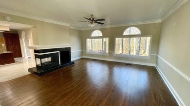 Unfurnished living room featuring baseboards, orna