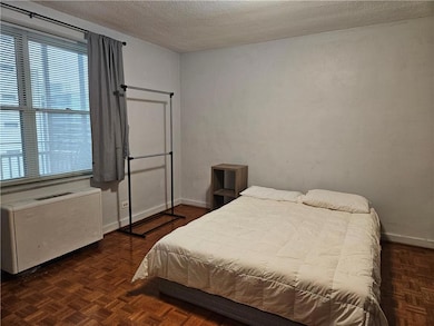Bedroom with a textured ceiling and baseboards