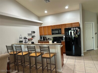 Kitchen featuring black appliances, a peninsula, b