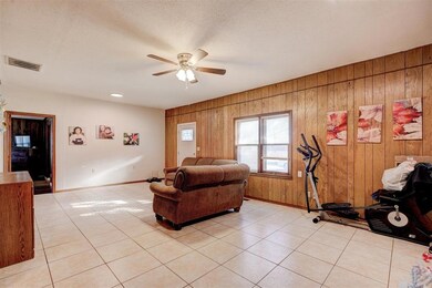 Living room with ceiling fan, a textured ceiling, 