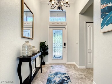 Entryway with crown molding, baseboards, marble fi