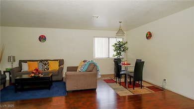 Living area with visible vents, baseboards, hardwo