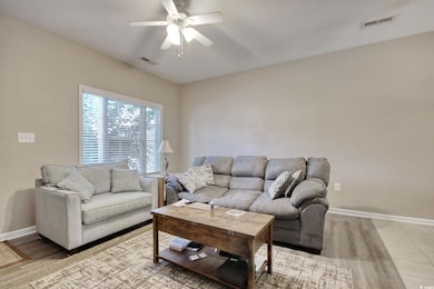 Living room featuring a ceiling fan and light wood-style floors