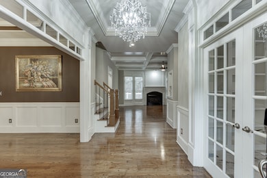 Grand foyer showcases coffered ceilings and an open view toward the living room.