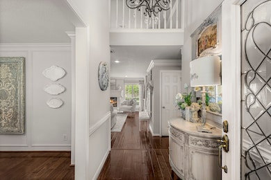 Once inside, you'll be captivated by the gorgeous interior! The first floor has been completely updated and remodeled over the years. The entry features a soaring ceiling, lit by a beautiful chandelier. Gleaming hardwood floors lead through the raised entry and dining room, as well as the living area, and the primary suite. Paint throughout is neutral and will blend with any décor.