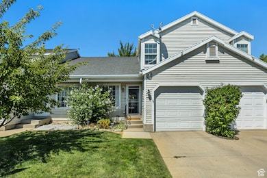 View of front facade featuring concrete driveway, a front lawn, a garage, entry steps, and a shingled roof