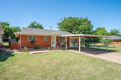 Ranch-style house featuring brick siding, a carport, and a gate