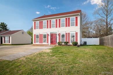 Colonial-style house with a front yard, fence, cen