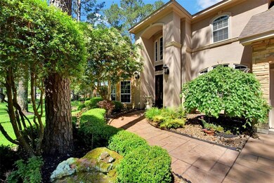 The inviting entry to the home has stained and stamped concrete sidewalk surrounded by lush landscaping.