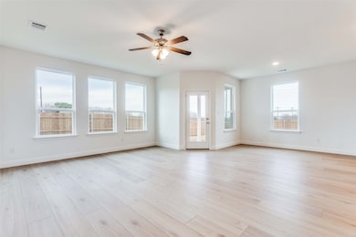 Unfurnished living room with ceiling fan and light hardwood / wood-style floors