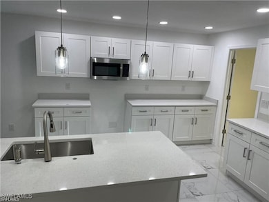 Kitchen with stainless steel microwave, light marb