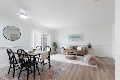 Dining room with wood finished floors, crown mold