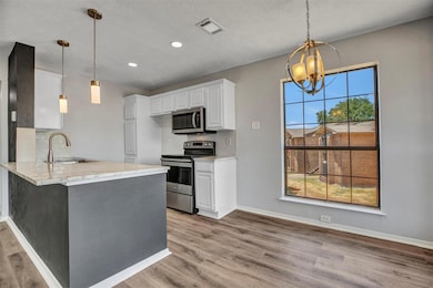 Kitchen with sink, tasteful backsplash, white cabi