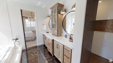 Bathroom featuring vanity, tile patterned floors, and a chandelier