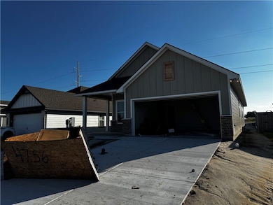 Single story home with board and batten siding, brick siding, concrete driveway, and an attached garage