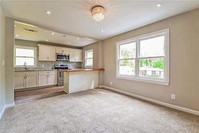 Kitchen with visible vents, white cabinets, basebo