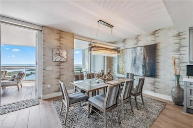 Dining room with wood-style flooring, wallpapered walls, and a water view