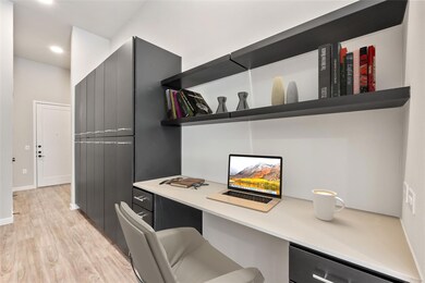 Office with built in desk, light wood-style floor