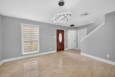Entry hallway highlights modern LED chandelier, fr