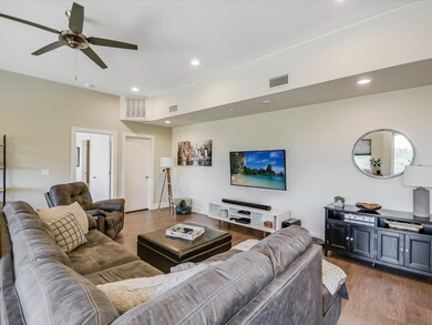 Living room with wood finished floors, ceiling fa