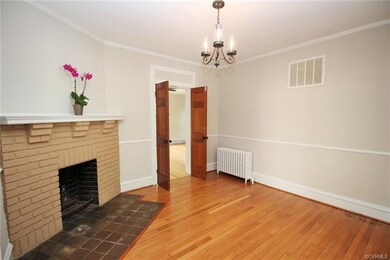 Dining Room with double doors to master, original tiered brick corbels supporting mantel, chair rail & crown