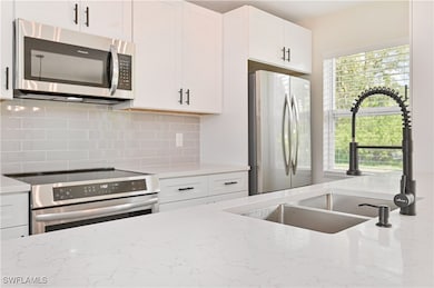 Kitchen with stainless steel appliances, a sink, h