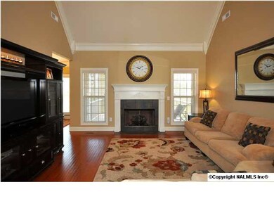 Great room features vaulted ceiling, gas log fireplace, wood floor, crown molding.