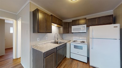 Kitchen with white appliances, light wood-style fl