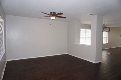 Spare room featuring dark wood-type flooring, a ceiling fan, and a chandelier
