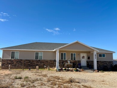 View of front of home with a porch, stone siding, and roof with shingles
