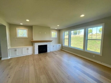 Spacious main floor Gathering Room with oversized windows and fireplace flanked by custom built in cabinets.