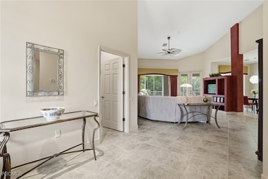 Living area with a ceiling fan and high vaulted ceiling