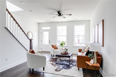 Living area with stairs, dark wood-style flooring,